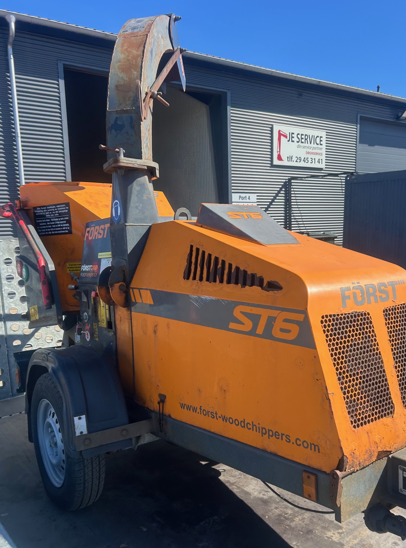 Eight shirts arranged on table in black, olive, grey, blue, white, red, mustard, and green.